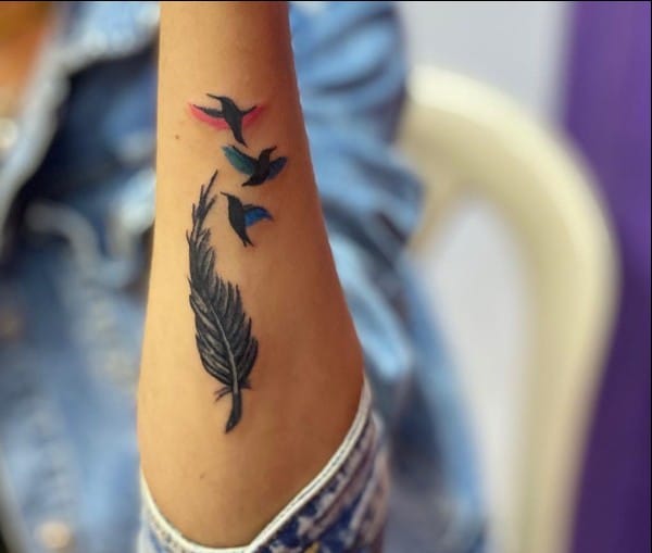 feather with birds tattoo on wrist