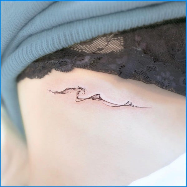 wave and mountain tattoos on ribs